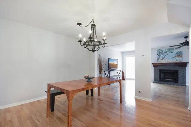 a dining room with furniture a chandelier and wooden floor