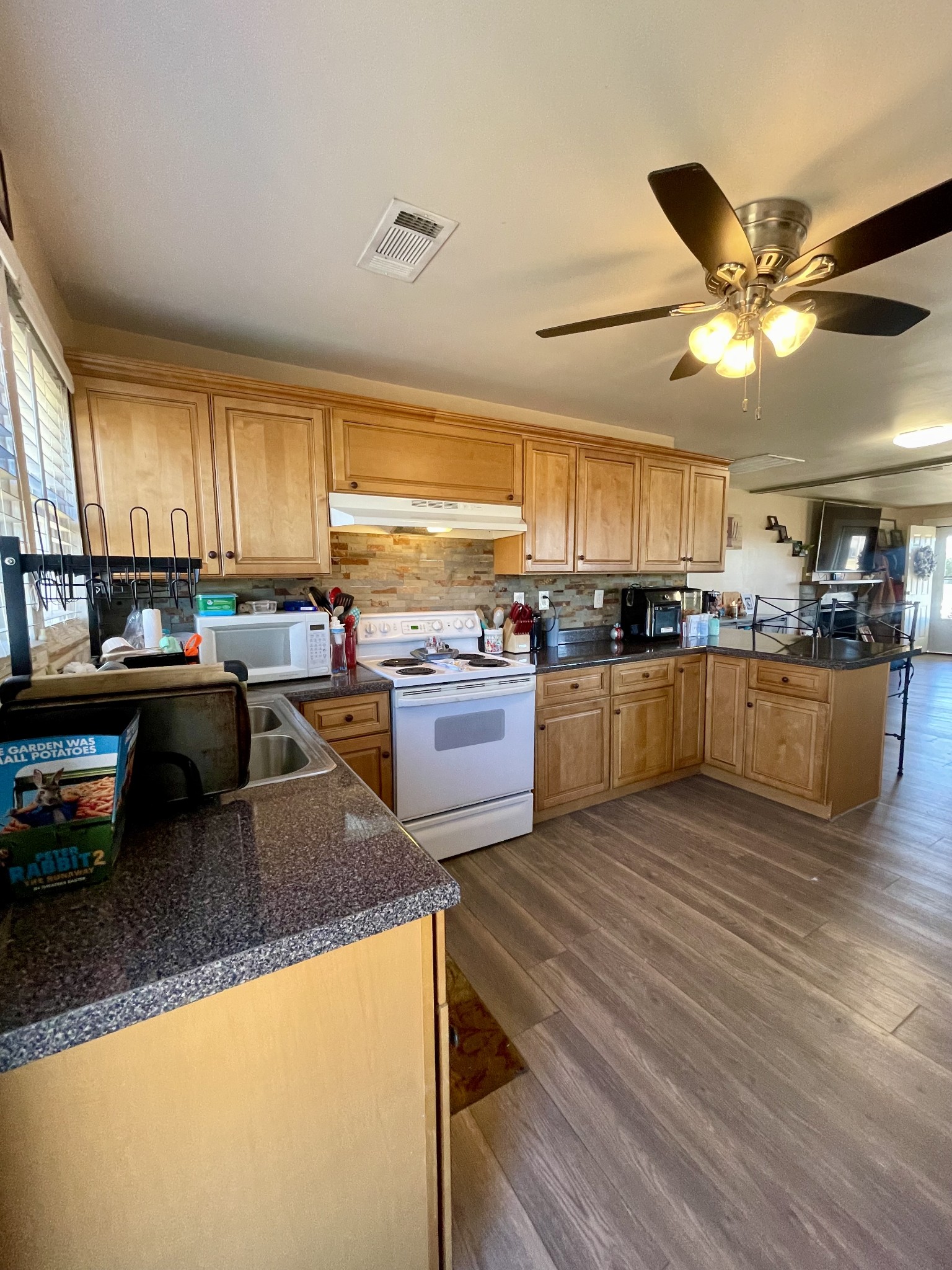968 West Point Road Lawrenceburg, TN 38464 - Photo 15 of 21 a kitchen with stainless steel appliances granite countertop wooden cabinets a sink a stove a dining table and chairs