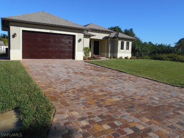 18225 Poplar Road Fort Myers, FL 33967 - Photo 4 of 21 a front view of a house with a yard and garage