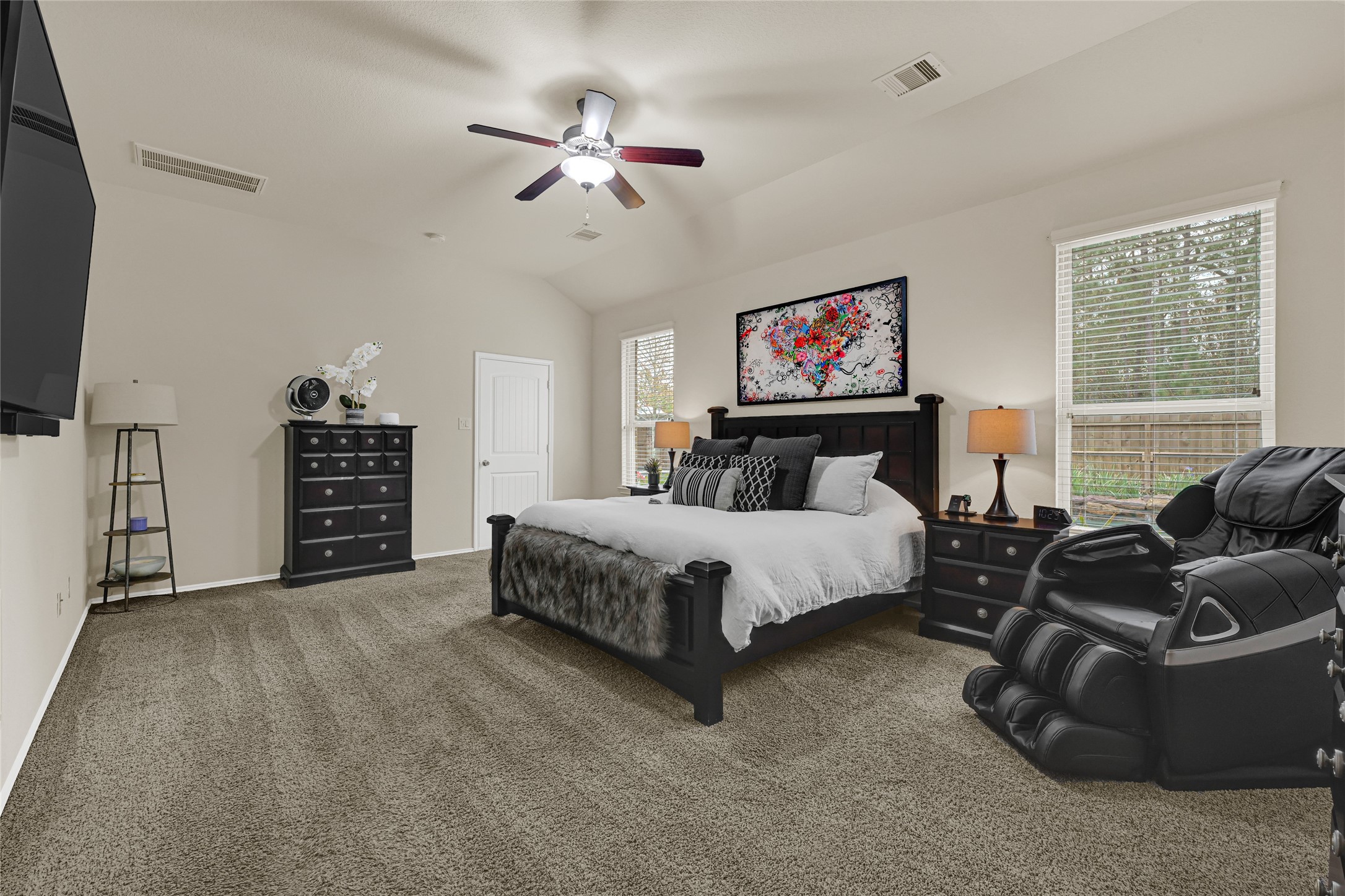 24303 Ravenna Landing Loop Spring, TX 77389 - Photo 21 of 46 a spacious bedroom with a bed a couch and a flat tv screen on the dresser