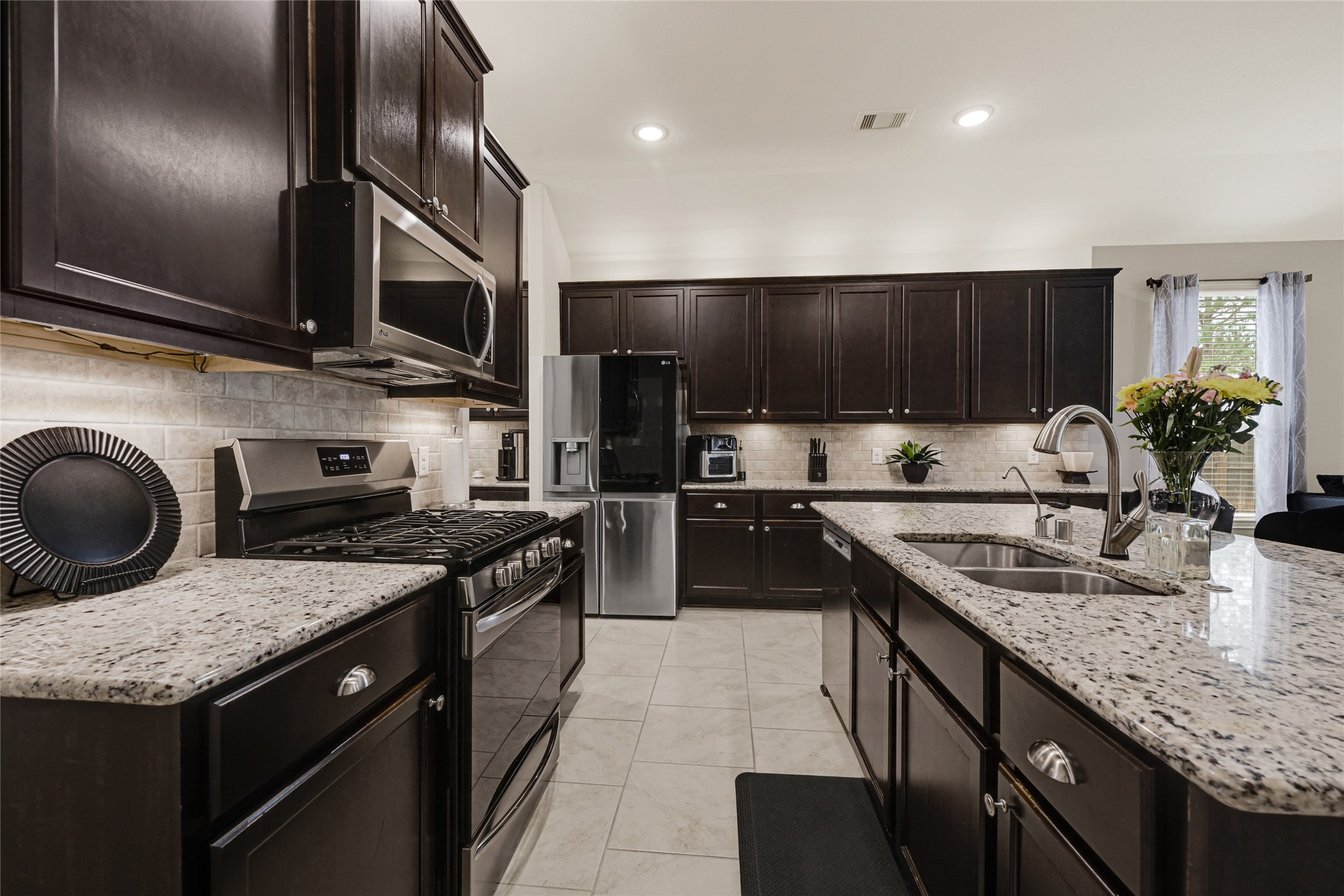 24303 Ravenna Landing Loop Spring, TX 77389 - Photo 7 of 46 a kitchen with granite countertop stainless steel appliances and wooden cabinets