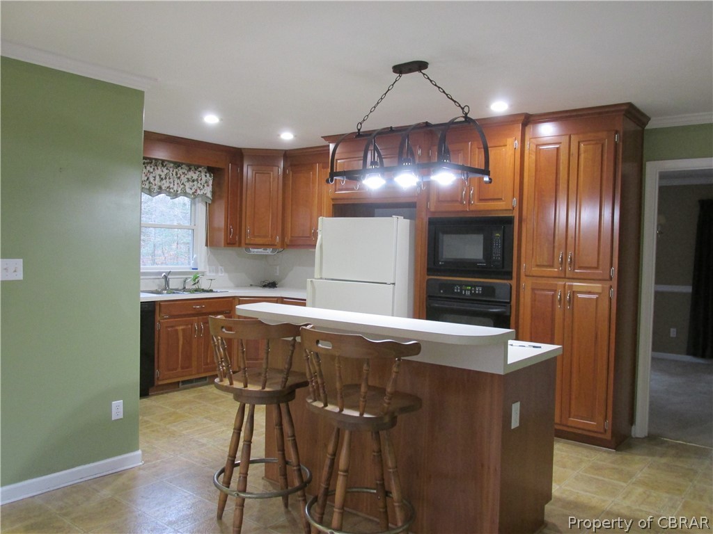 669 Croxtons Road Jamaica, VA 23079 - Photo 8 of 33 Beautiful cabinets highlight this roomy kitchen with center work space with flat surface cooktop. Built in microwave and oven. All appliances convey.