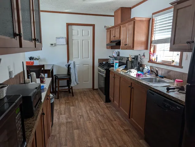 a kitchen with refrigerator cabinets and wooden floor