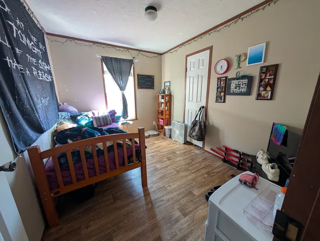 a bedroom with furniture and wooden floor