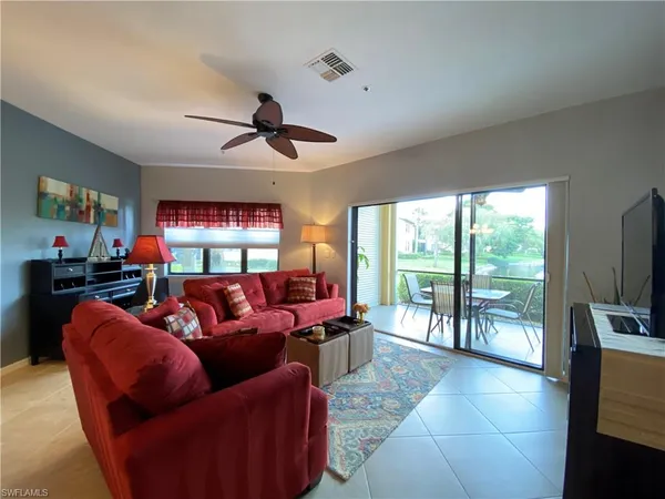 a living room with furniture a ceiling fan and a floor to ceiling window