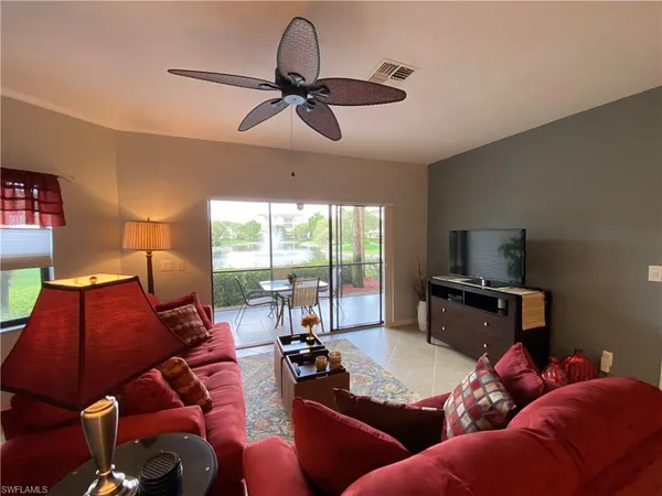 a living room with furniture ceiling fan and a window