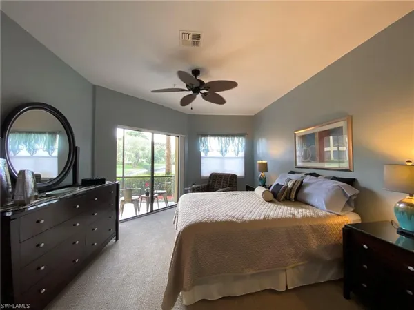 a bedroom with a bed and a large mirror with a chandelier