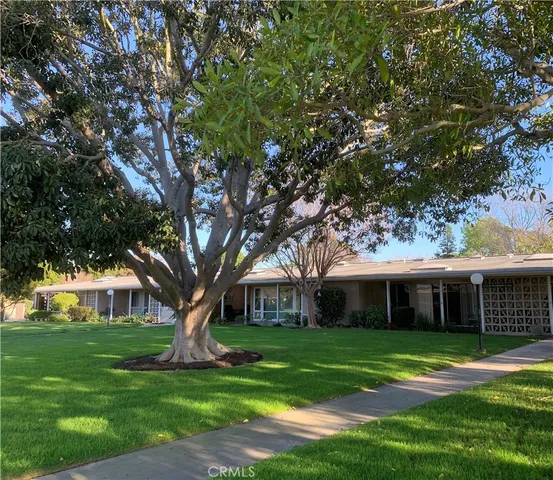 a front view of a house with a garden and trees