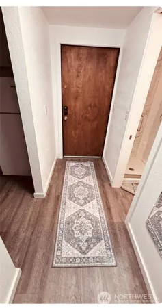 view of an empty room with wooden floor and a rug