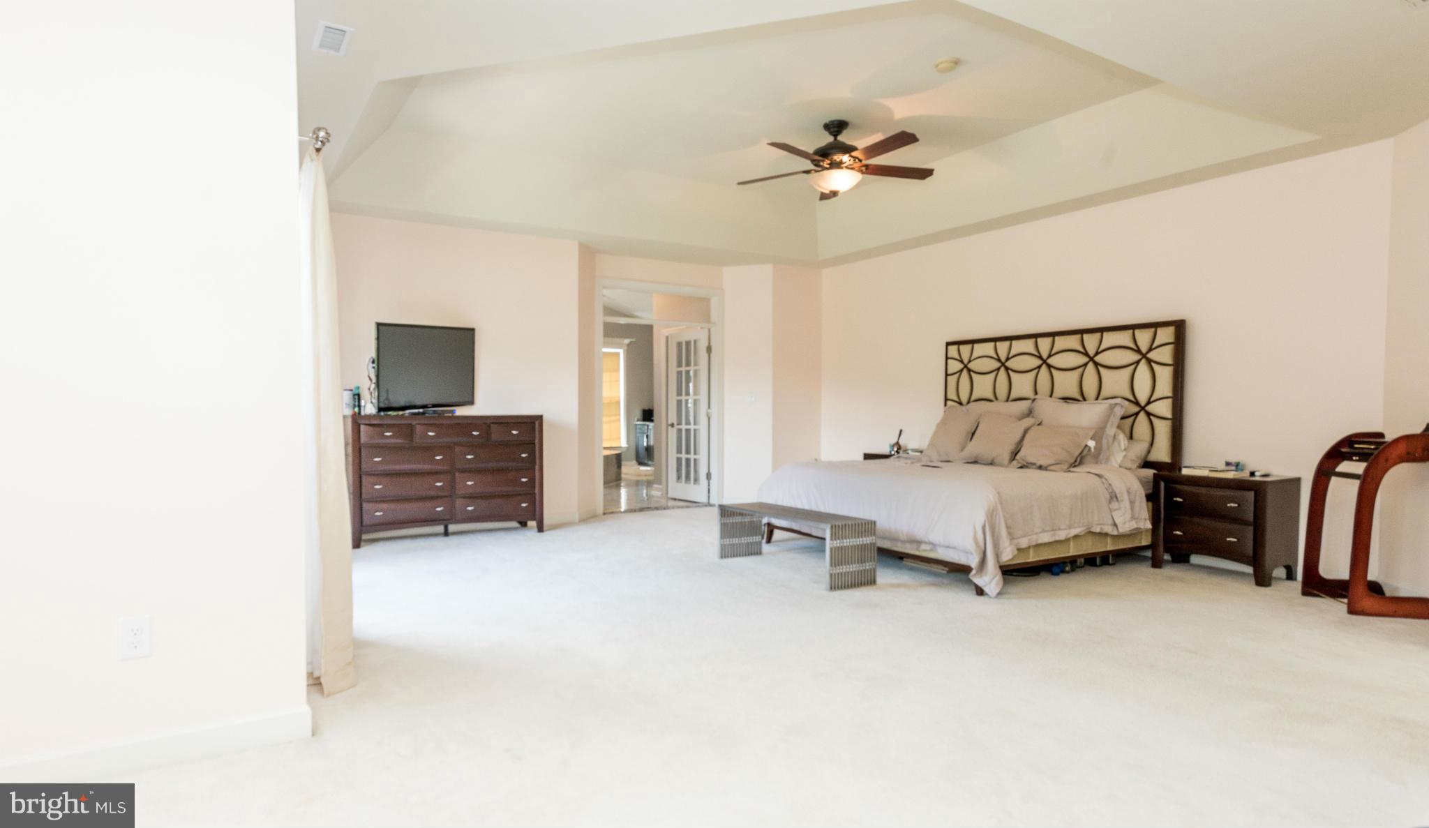 2302 Parlor Court Fallston, MD 21047 - Photo 20 of 30 a spacious bedroom with a bed and a chandelier