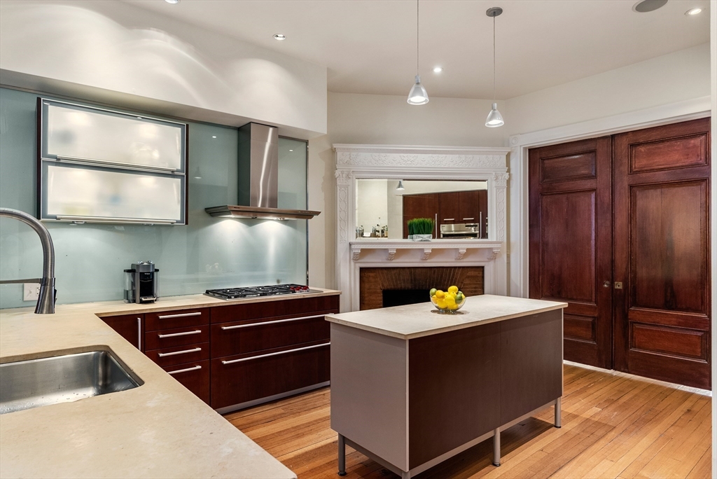 37 Bay State Road, Unit 3 Boston, MA 02215 - Photo 5 of 18 a kitchen with stainless steel appliances kitchen island granite countertop a stove a sink and a microwave