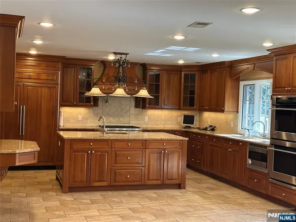 a kitchen with stainless steel appliances granite countertop wooden cabinets a sink and a stove