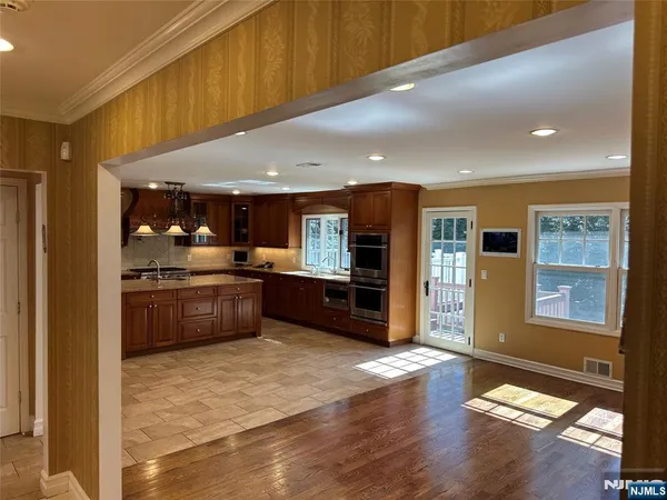a kitchen with stainless steel appliances kitchen island granite countertop a refrigerator and cabinets