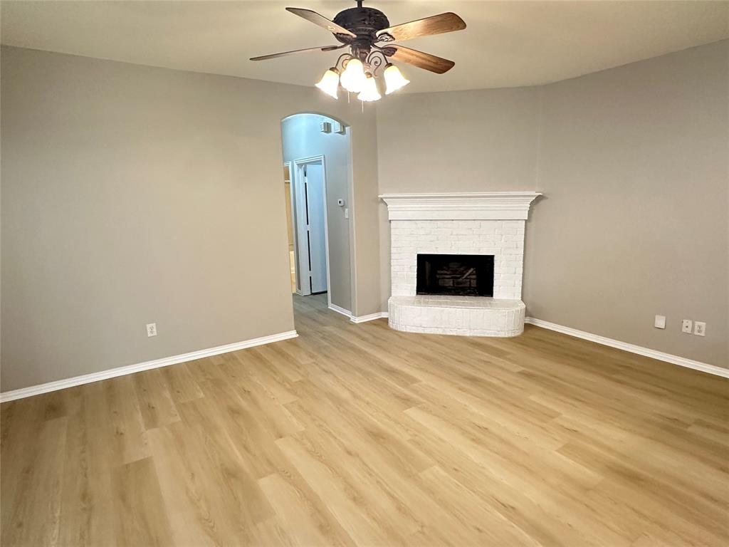 a view of empty room with fan and fireplace