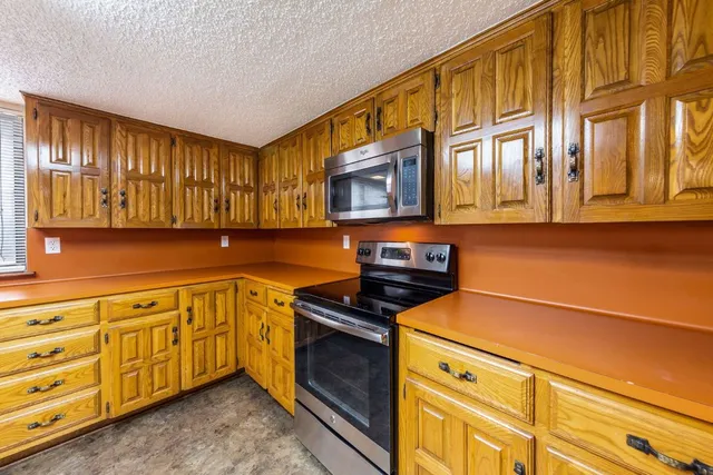 a kitchen with stainless steel appliances granite countertop a stove and a microwave