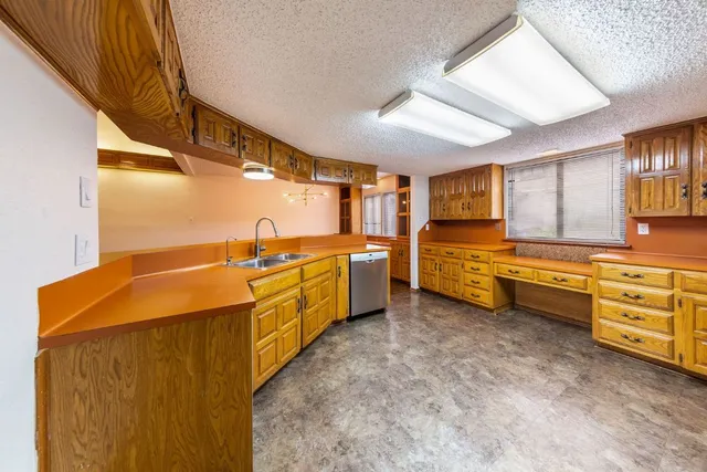 a open kitchen with cabinets a sink and wooden floors