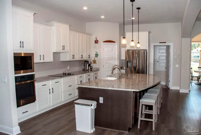 a bathroom with a granite countertop sink toilet and mirror