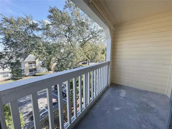 a view of a balcony with wooden floor and fence