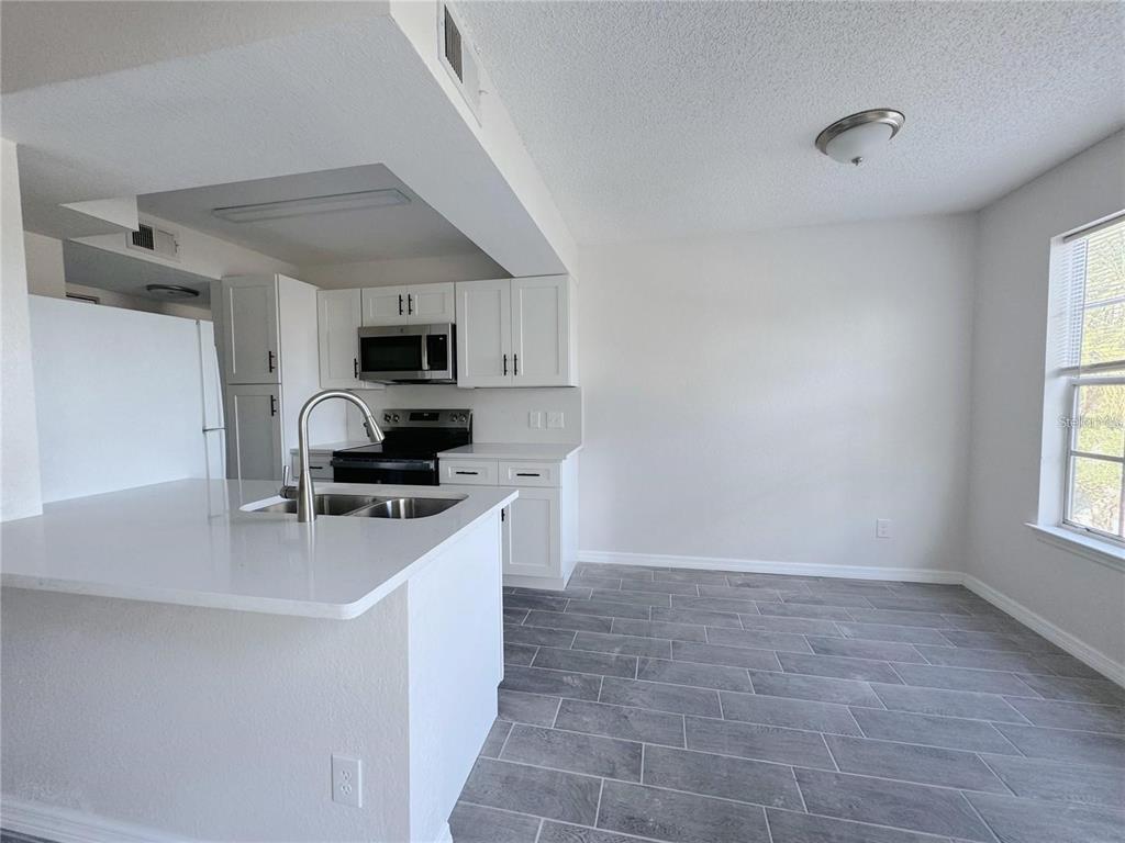 1013 South Hiawassee Road, Unit 3635 Orlando, FL 32835 - Photo 5 of 18 a kitchen with a sink a microwave and cabinets