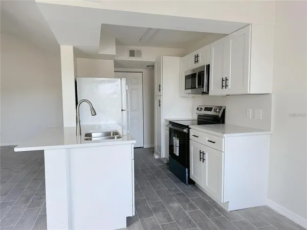 a kitchen with stainless steel appliances a sink stove and refrigerator