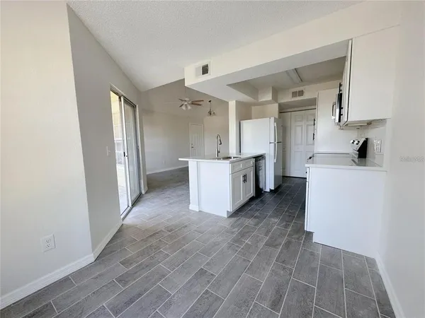 a view of a kitchen with wooden floor and electronic appliances