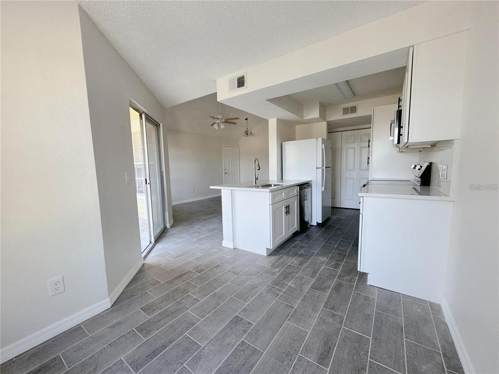 1013 South Hiawassee Road, Unit 3635 Orlando, FL 32835 - Photo 8 of 18 a view of a kitchen with wooden floor and electronic appliances