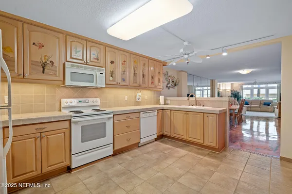 a kitchen with a sink a refrigerator and cabinets