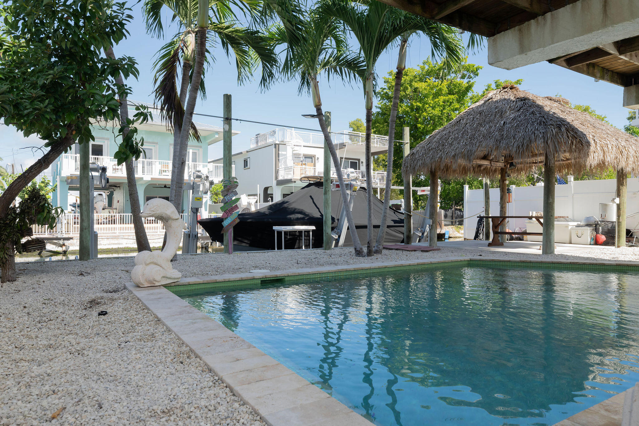 27 Avenue D Key Largo, FL 33037 - Photo 21 of 69 a view of a swimming pool with a table and chairs under an umbrella