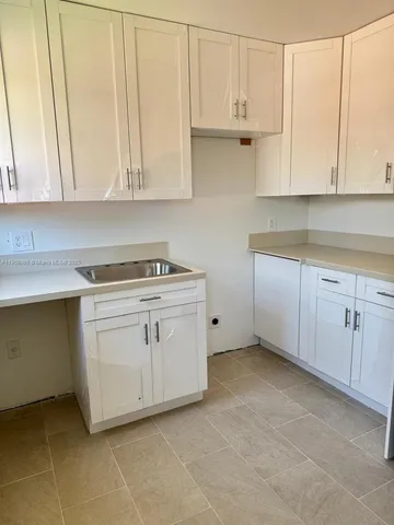 a kitchen with white cabinets and white appliances