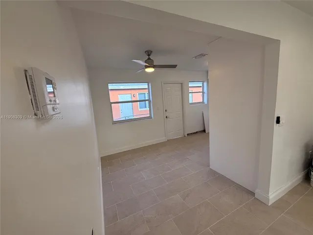 an empty room with windows and fan