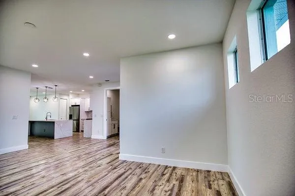 a view of a kitchen with a refrigerator and wooden floor