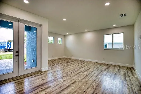 a kitchen with stainless steel appliances granite countertop a sink a stove and a wooden floors
