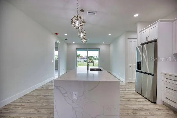 a kitchen with stainless steel appliances granite countertop a sink a stove and a wooden floors