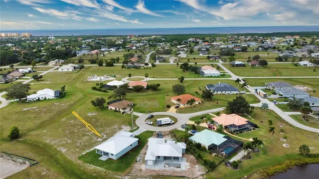 an aerial view of a house with a garden and lake view