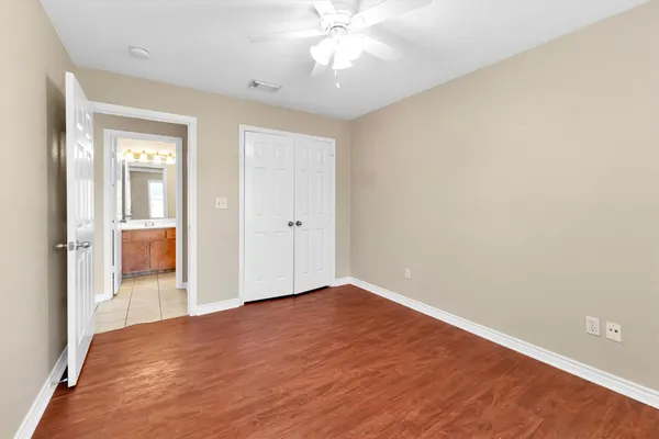 an empty room with a window and a fan