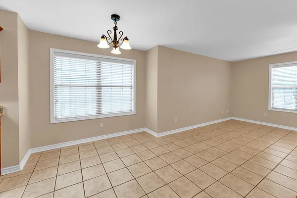 a view of an empty room with window and mirror