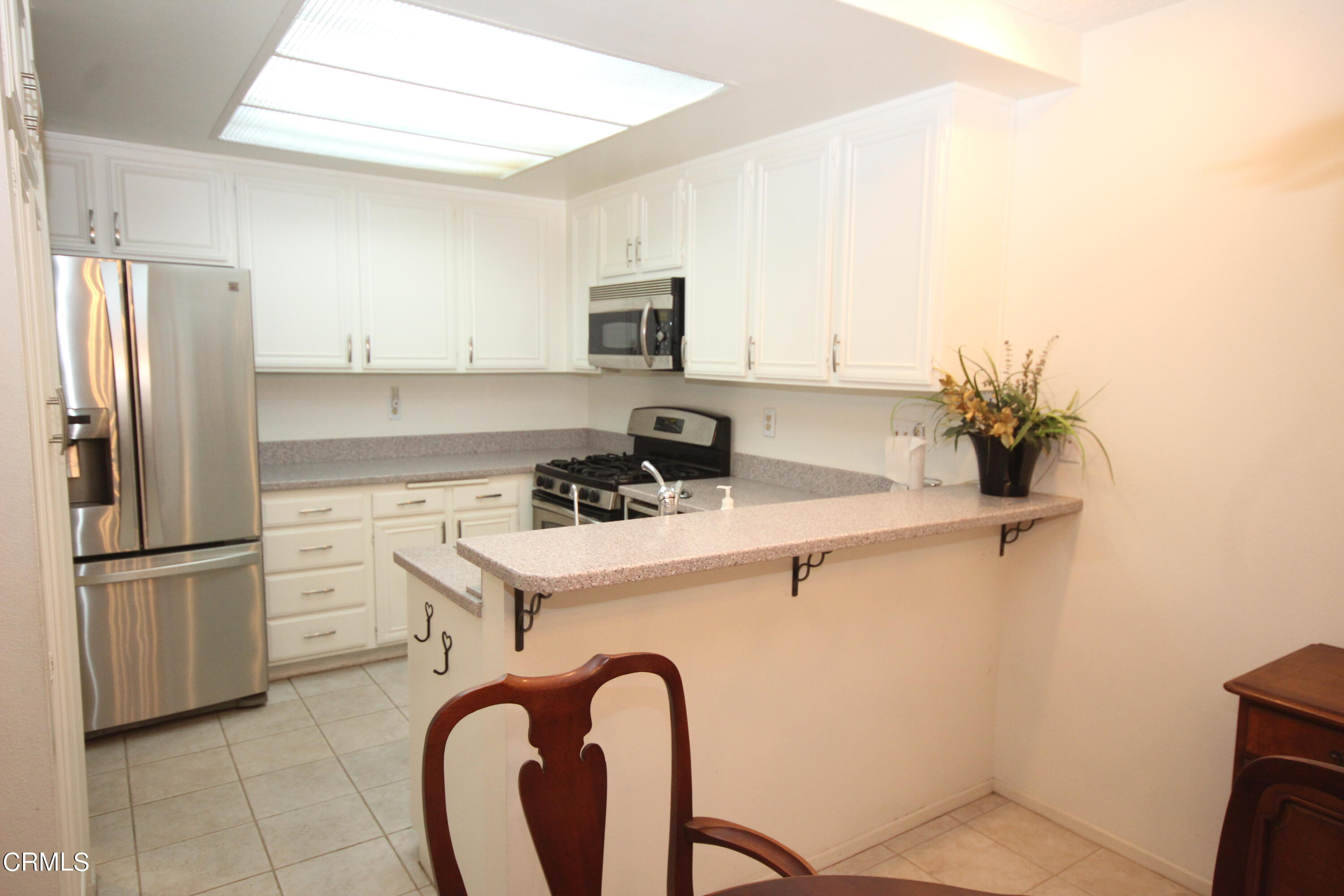 3354 Sunset Lane Oxnard, CA 93035 - Photo 4 of 12 a kitchen with stainless steel appliances a refrigerator sink and white cabinets