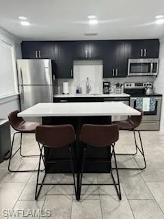 a kitchen with stainless steel appliances granite countertop a refrigerator a stove a sink dishwasher a dining table and chairs with wooden floor