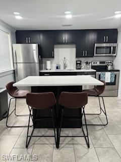 a kitchen with stainless steel appliances granite countertop a refrigerator a stove a sink dishwasher a dining table and chairs with wooden floor