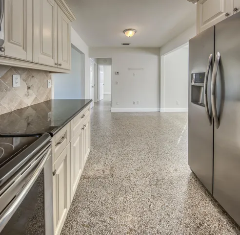 a kitchen with stainless steel appliances granite countertop a refrigerator and a stove