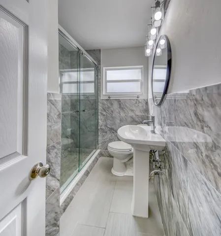 a bathroom with a toilet a sink and mirror