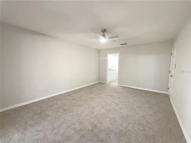 an empty room with a ceiling fan and a window