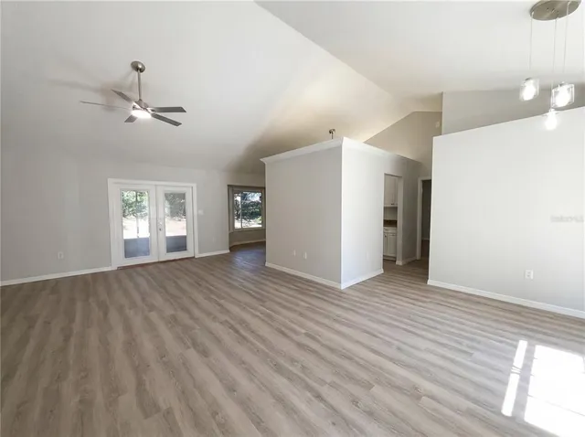 a view of an empty room with a window and wooden floor