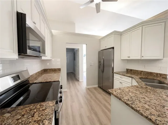 a kitchen with granite countertop wooden cabinets and a stainless steel appliances