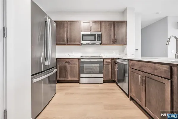 a kitchen with stainless steel appliances granite countertop a stove top oven and cabinets