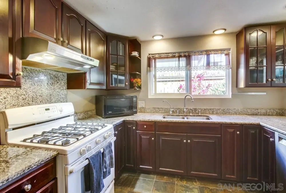 9337 Goyette Place Santee, CA 92071 - Photo 15 of 20 a kitchen with a sink stove and cabinets