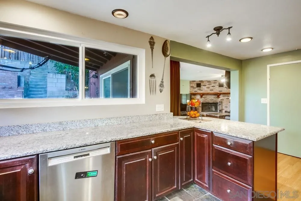 9337 Goyette Place Santee, CA 92071 - Photo 17 of 20 a kitchen with stainless steel appliances granite countertop a sink and dishwasher with wooden cabinets