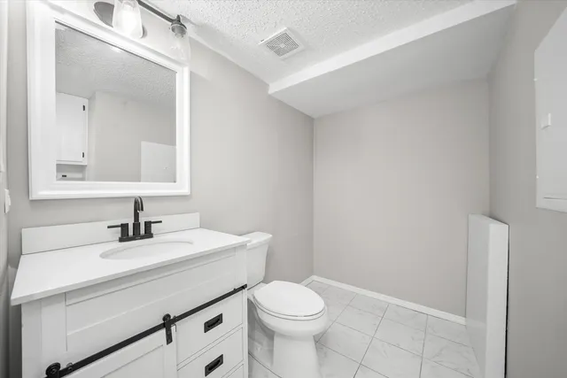 a bathroom with a sink mirror vanity and toilet