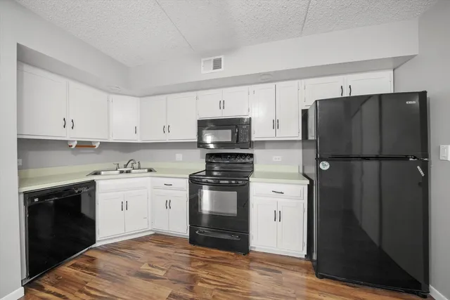 a kitchen with a refrigerator stove and white cabinets