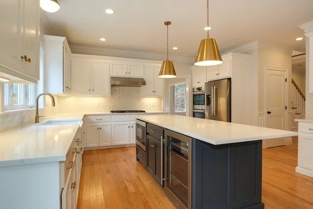 a kitchen with granite countertop a sink a counter space appliances and a window